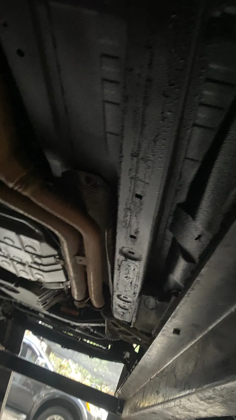 Underside of the sill and floor coated in black from below, exhaust pipes