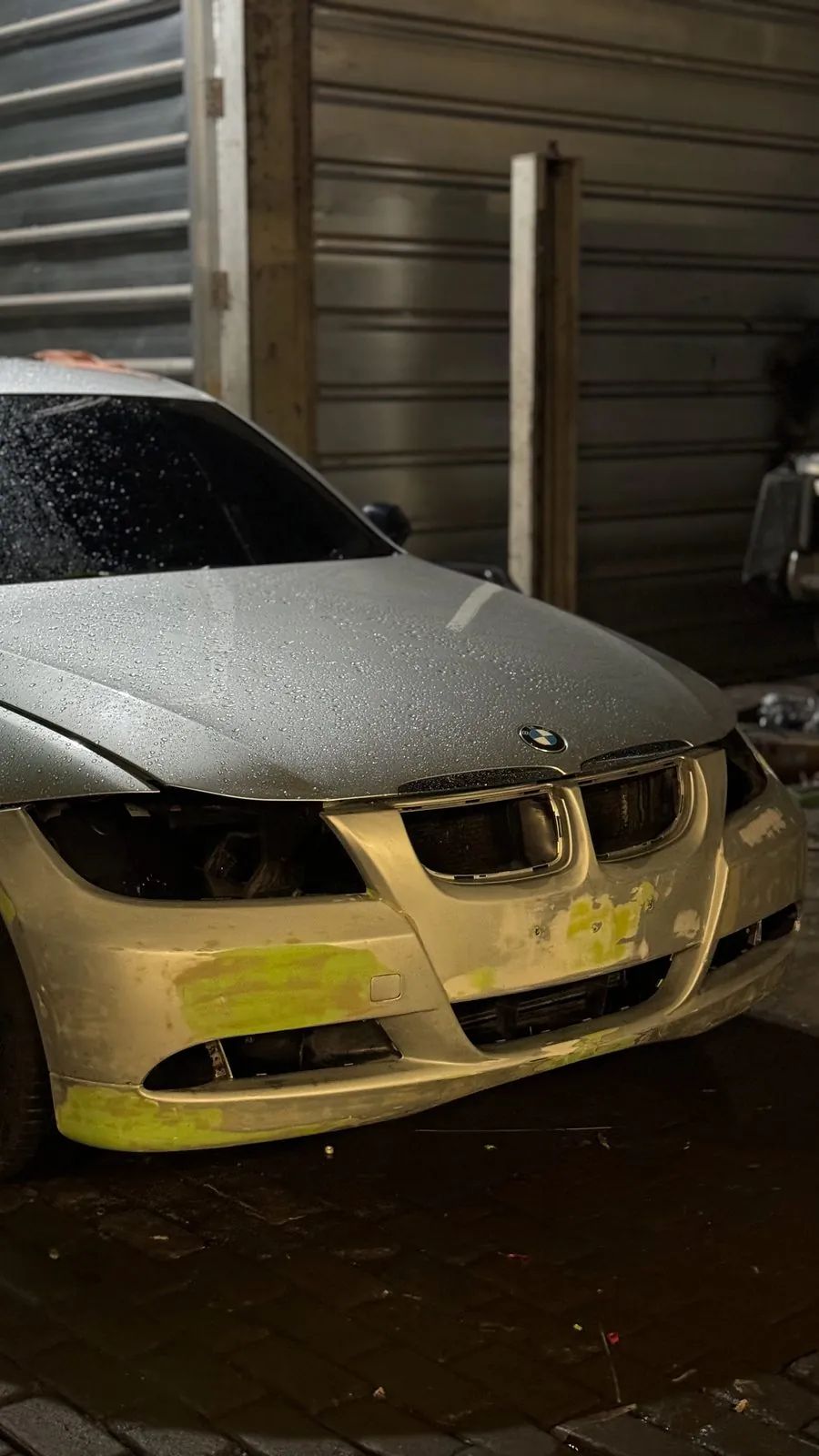 Front of silver E90 with bumper in primer and filler, roundel on the bonnet