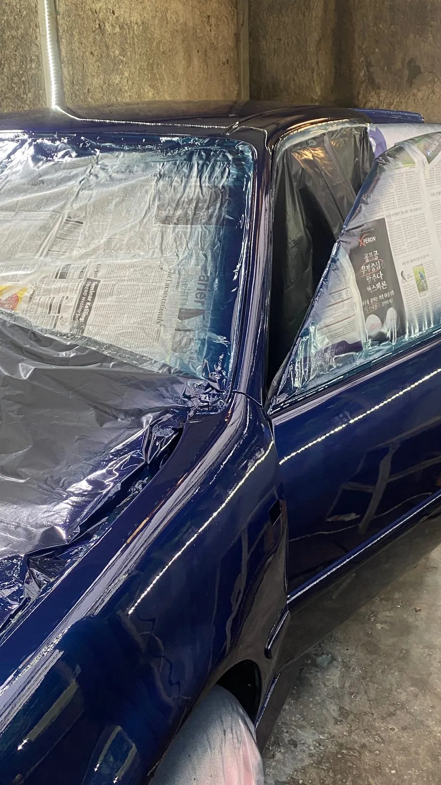 Bonnet and wing freshly sprayed, windows masked with newspaper